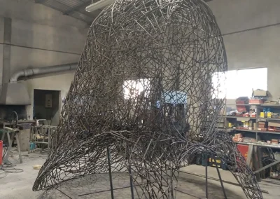 "Imponente escultura de hierro del Cap de Dimoni en la entrada de Santa Margalida, Mallorca." "Monumental obra del Cap de Dimoni, emblema de la tradición y la artesanía de Santa Margalida." "La Escultura del Cap de Dimoni en Santa Margalida, un punto de encuentro cultural en Mallorca." "Vista de la escultura del Cap de Dimoni en Santa Margalida, reflejo de las fiestas de la Beata." "El Cap de Dimoni de Santa Margalida, un hito artístico forjado en hierro en el corazón de Mallorca."