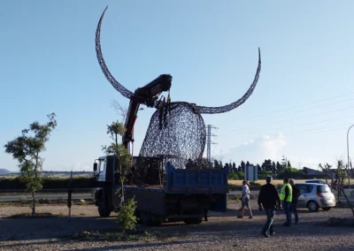 "Imponente escultura de hierro del Cap de Dimoni en la entrada de Santa Margalida, Mallorca." "Monumental obra del Cap de Dimoni, emblema de la tradición y la artesanía de Santa Margalida." "La Escultura del Cap de Dimoni en Santa Margalida, un punto de encuentro cultural en Mallorca." "Vista de la escultura del Cap de Dimoni en Santa Margalida, reflejo de las fiestas de la Beata." "El Cap de Dimoni de Santa Margalida, un hito artístico forjado en hierro en el corazón de Mallorca."